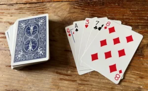 Two players flipping cards in a War card game on a table.